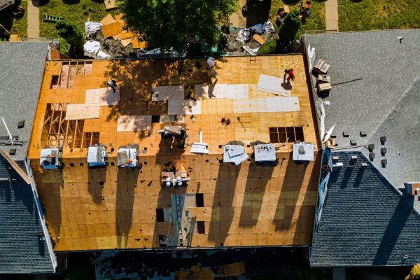 A worker replace shingles on the roof of a home repairing the roof of a home