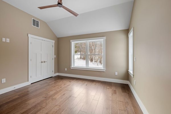 A modern living room interior showcasing hardwood flooring and a ceiling fan